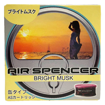 Packaging for Air Spencer car air freshener in 'Bright Musk' scent, featuring a silhouette of a woman against a sunset over the ocean, with a pink canister displayed in the corner