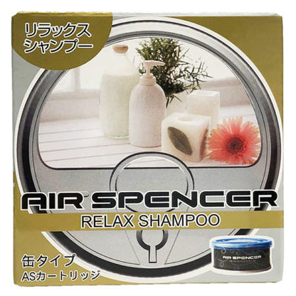 Air Spencer car air freshener in 'Relax Shampoo' scent, depicting a serene bathroom setting with toiletries and a bright flower, alongside a blue canister